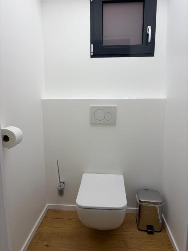 a bathroom with a white toilet and a mirror at Studio de standing in Malakoff