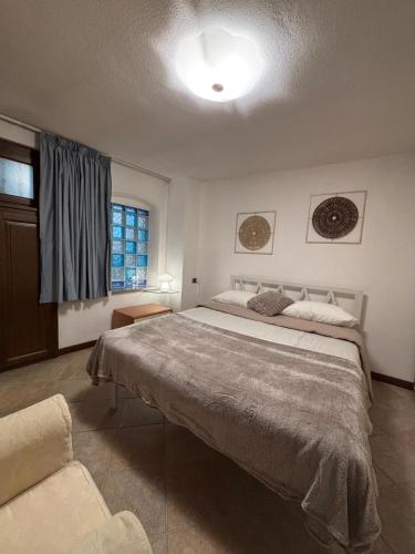 a bedroom with a large bed and a window at Chez Néné in Châtillon