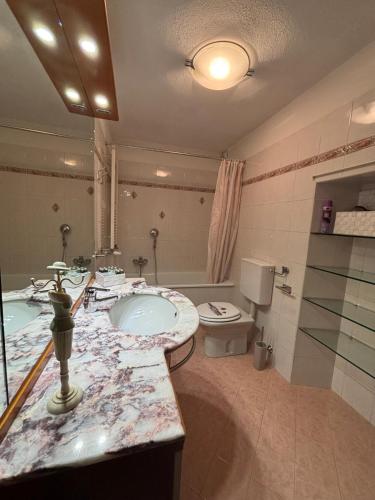 a bathroom with a sink and a toilet at Chez Néné in Châtillon
