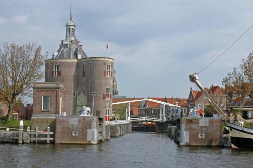 a building in the water next to a river at El Puerto Bed and Breakfast in Hoorn