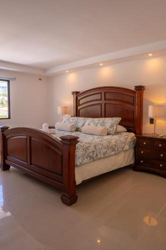 a bedroom with a large wooden bed and a nightstand at Refugio urbano in Nuevo Cuscatlán