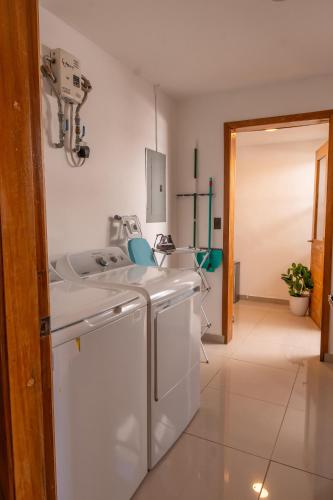 a kitchen with a washing machine and a sink at Refugio urbano in Nuevo Cuscatlán