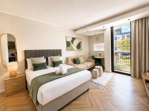 a bedroom with a large bed and a couch at On Park Luxury One Bed & Bath- in Cape Town