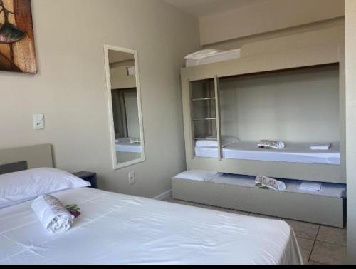 a hotel room with two beds and a mirror at Loft aconchegante no Centro in Joinville
