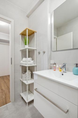 a white bathroom with a sink and a mirror at Apartment Katja in Vantačići