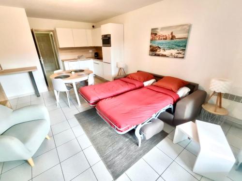 a living room with a couch with a red blanket at Barcaresa - Malibu village Catalan T2 terrasse in Canet-en-Roussillon