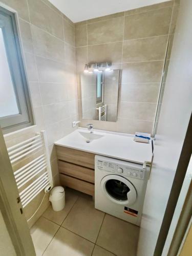a bathroom with a washing machine and a sink at Barcaresa - Malibu village Catalan T2 terrasse in Canet-en-Roussillon