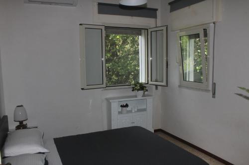 a bedroom with a bed and two windows at Villa Torre in Acquafredda
