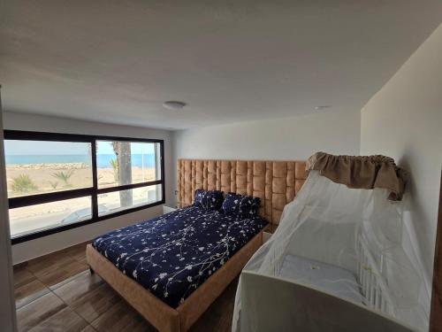 a bedroom with a bed and a large window at Dar Julia Seaview Apartment in Mahdia