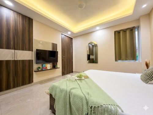 a bedroom with a bed with a television and a table at The verdant corner in Gurgaon