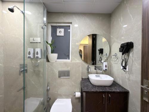 a bathroom with a sink and a toilet and a mirror at The verdant corner in Gurgaon