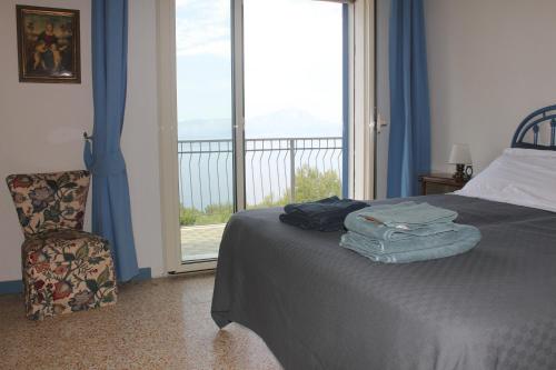 a bedroom with a bed and a window and a chair at Villa Torre in Acquafredda