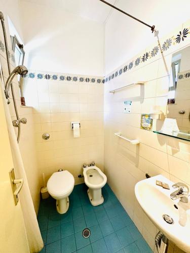a bathroom with a toilet and a sink at Hotel Solitude in Riccione
