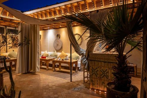 a patio with couches and a potted plant at Riad MISS CARACAL Jacuzzi & Rooftop in Marrakesh