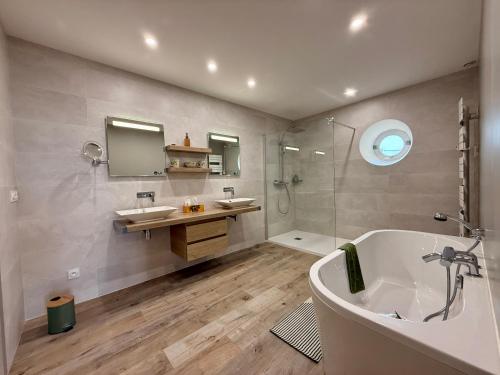 a bathroom with a tub and two sinks and a shower at La Belle Eclusière in Homps