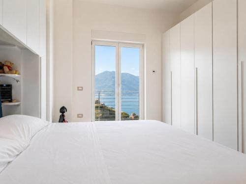 a bedroom with a white bed and a large window at Villa Carpediem - Luxury Private Stay Front Sea Portofino Coast in Recco