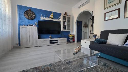 a living room with a couch and a tv at Giuly Sole e Sale in Le Grazie