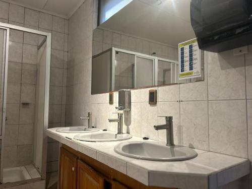 a bathroom with two sinks and a shower at Hostal Don Guillermo in Puerto Natales