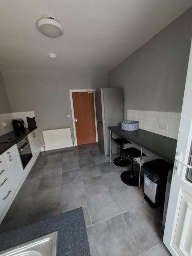 an empty kitchen with a table and a refrigerator at Alice House Long stays in Sunderland