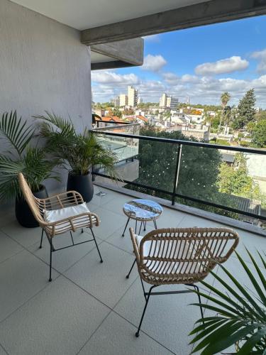 two chairs and a table on a balcony with a view at Concepto Home in Rafaela