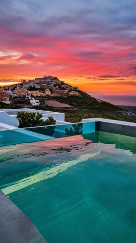 a swimming pool with a sunset in the background at Martynou View in Pyrgos