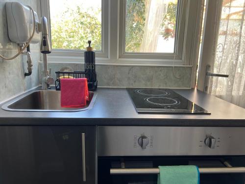 a kitchen counter with a sink and a stove at Westcliff Cottage in Southend-on-Sea