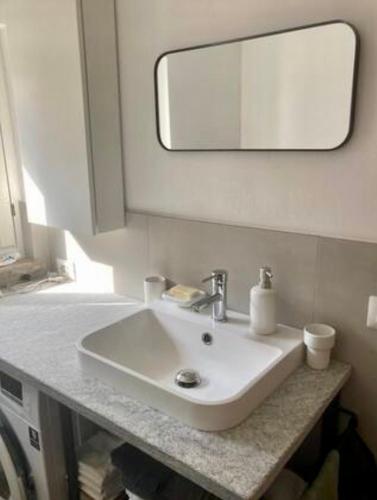 a bathroom with a white sink and a mirror at Baita LoKa-Baita panoramica tra Lago di Como e Grigna in Bellano