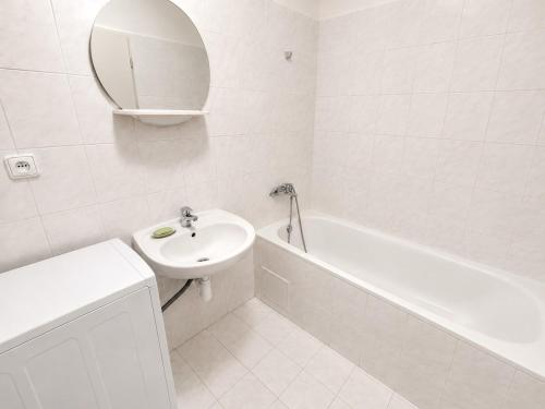 a white bathroom with a sink and a mirror at Moderní studio s terasou v klidné lokalitě in Jihlava