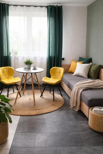 a living room with a bed and a table and chairs at Powidz Comfort Suites in Powidz