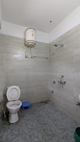 a bathroom with a toilet and a light on the wall at Kunzang Homestay in Shalkār