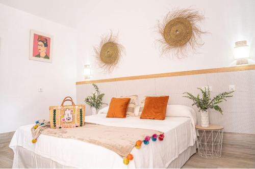 a bedroom with a white bed with orange pillows at Hotel La Villoría in Medina Sidonia