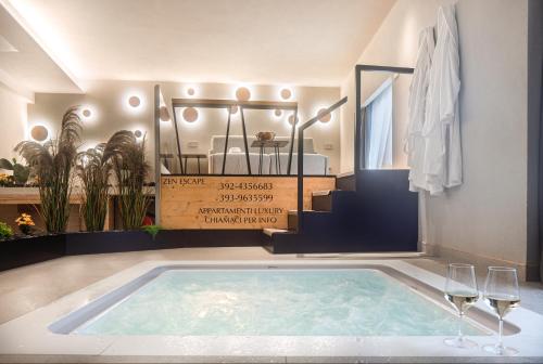 a swimming pool in a bathroom with glasses of wine at Zen escape Sicilia in San Gregorio di Catania