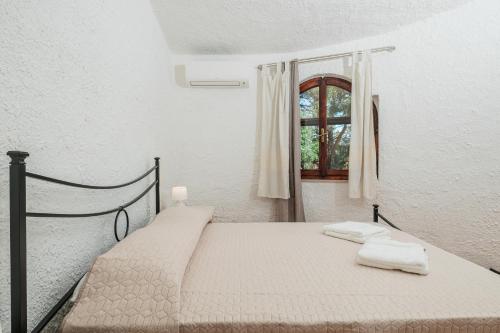 a bedroom with a bed with two towels on it at Casa P - Relax nel verde a Ezzi Minori in Cuile Ezi Mannu