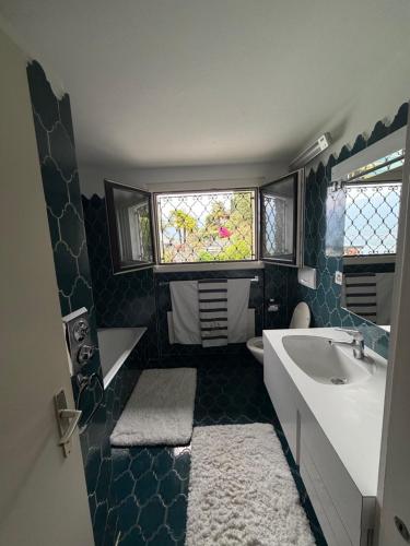 a bathroom with a tub and a sink and a window at Mediterranes Lebensgefühl Tessin in Gerra