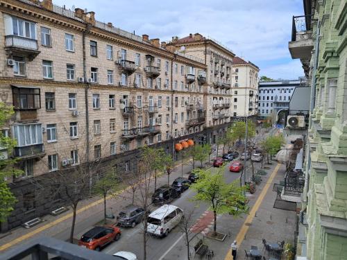 a city street with cars parked in front of buildings at Summit Apartments in Kyiv