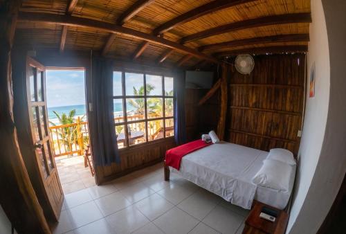 a bedroom with a bed and a view of the ocean at Cocoa Beachfront Inn in Canoa