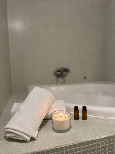 a candle and towels on a bathroom counter with a bath tub at Agriturismo Cerrosughero in Canino