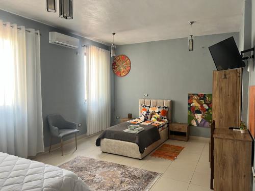 Host Apartments في شكودر: غرفة نوم بها سرير وتلفزيون على الحائط