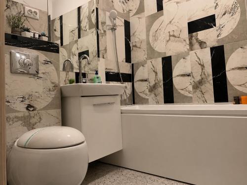 a bathroom with a toilet and a sink and a tub at Studio Luxury Center in Iaşi