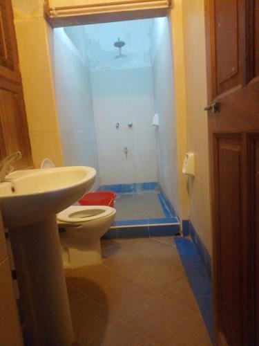 a bathroom with a white toilet and a sink at Magram House in Lamu