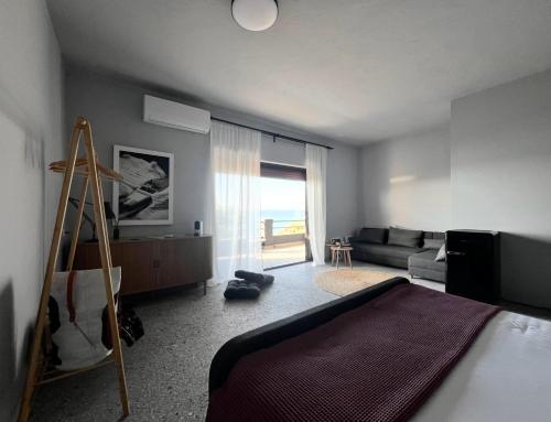 a bedroom with a bed and a living room at hellofrom Beach House in Loutrá Elevtherón