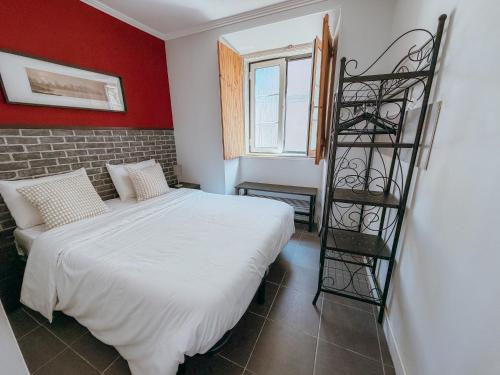 a bedroom with a white bed and a ladder at Aliciamar 29 by Casas de Setúbal in Setúbal