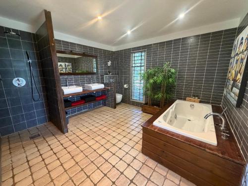 a bathroom with a tub and a shower and a sink at Villa d'architecte avec piscine in Saint-François