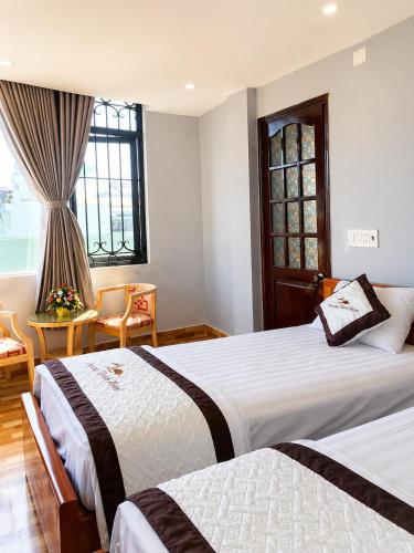 a hotel room with two beds and a window at Khách sạn Phương Danh in Phú Tài (1)