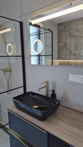 a bathroom with a black sink and a mirror at Apartman Bartimej 3 in Bobrów