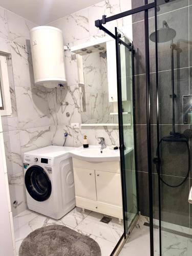 a bathroom with a washing machine and a sink at Apartment Guberinic in Tivat