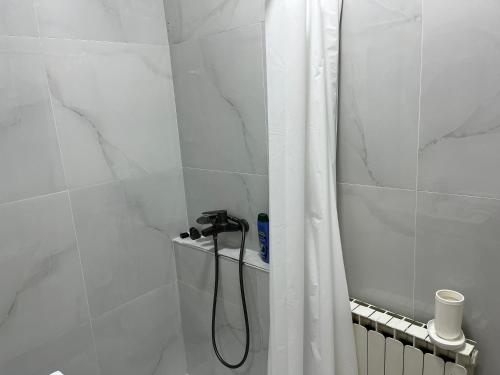 a shower with a shower curtain in a bathroom at Center City Stay 2 in Skopje