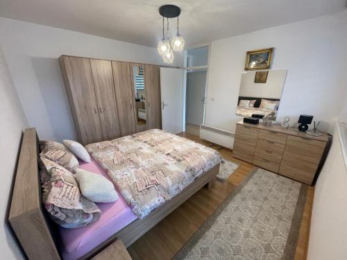 a bedroom with a large bed and a dresser at Apartman Deluxe in Novi Travnik