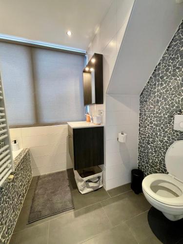 a bathroom with a toilet and a sink and a window at Room at the Beach Egmond in Egmond aan Zee