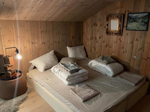 a bedroom with a bed with pillows on it at Moderne hytte ved sjøen med badstue in Rømskog